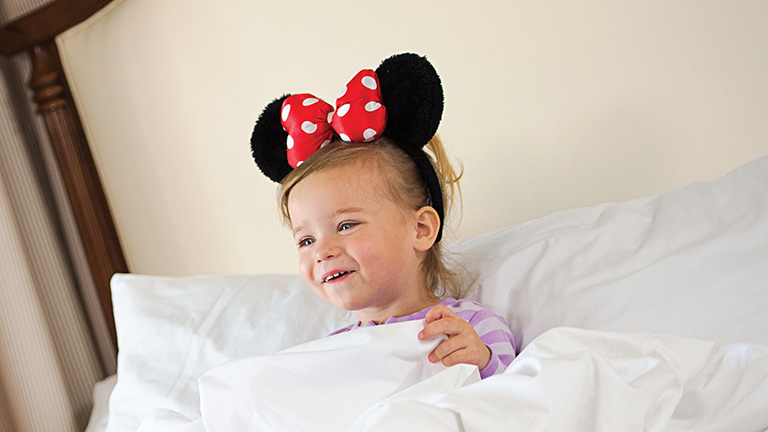 Young guest in bed, wearing Minnie ears
