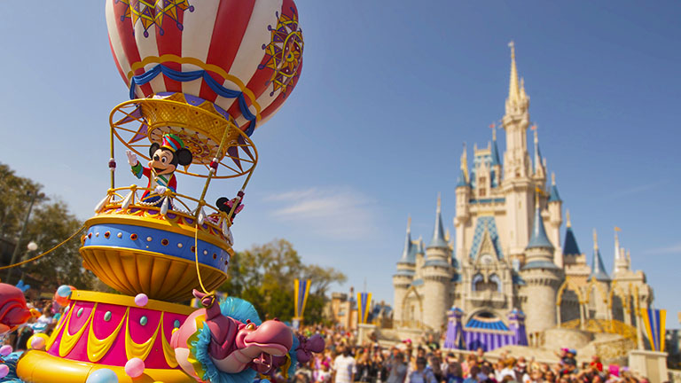 Mickey Mouse in a float, waving during the parade in Magic Kingdom