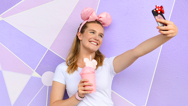 Teen posing in front of the purple wall in Magic Kingdom