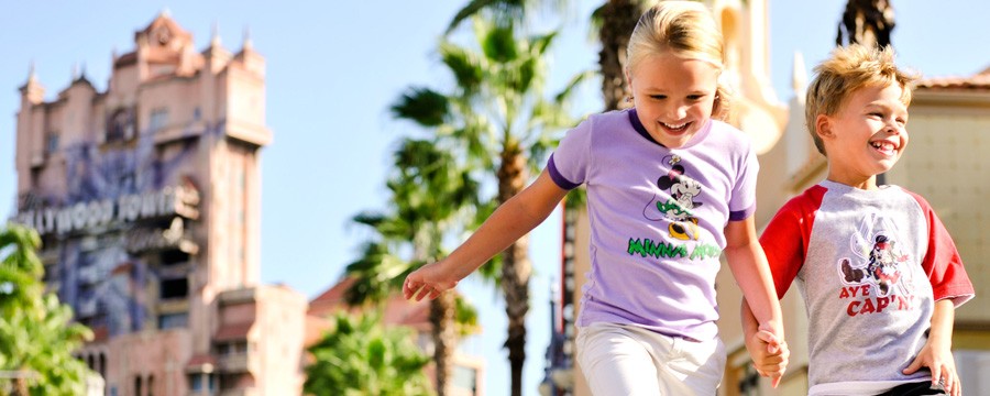 Girl and boy holding hands and skipping down the street at Disney's Hollywood Studios theme park